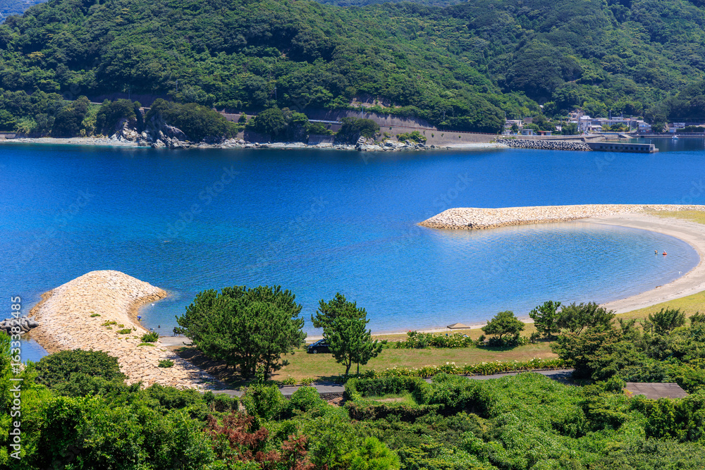 Fototapeta premium 半月型の砂浜と青い海が美しいムーンビーチ井野浦の夏景色
