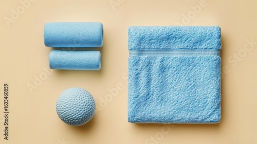Light-blue cylindrical items and a folded towel on a pastel-yellow surface