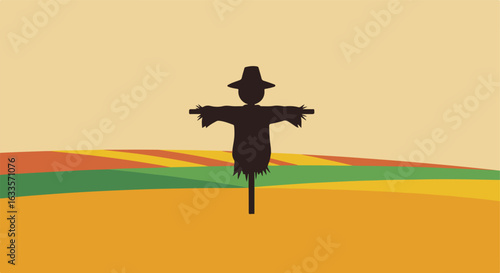 Scarecrow silhouette stands tall in a field with autumn colors
