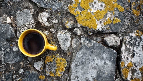Yellow mug of coffee on a stone path