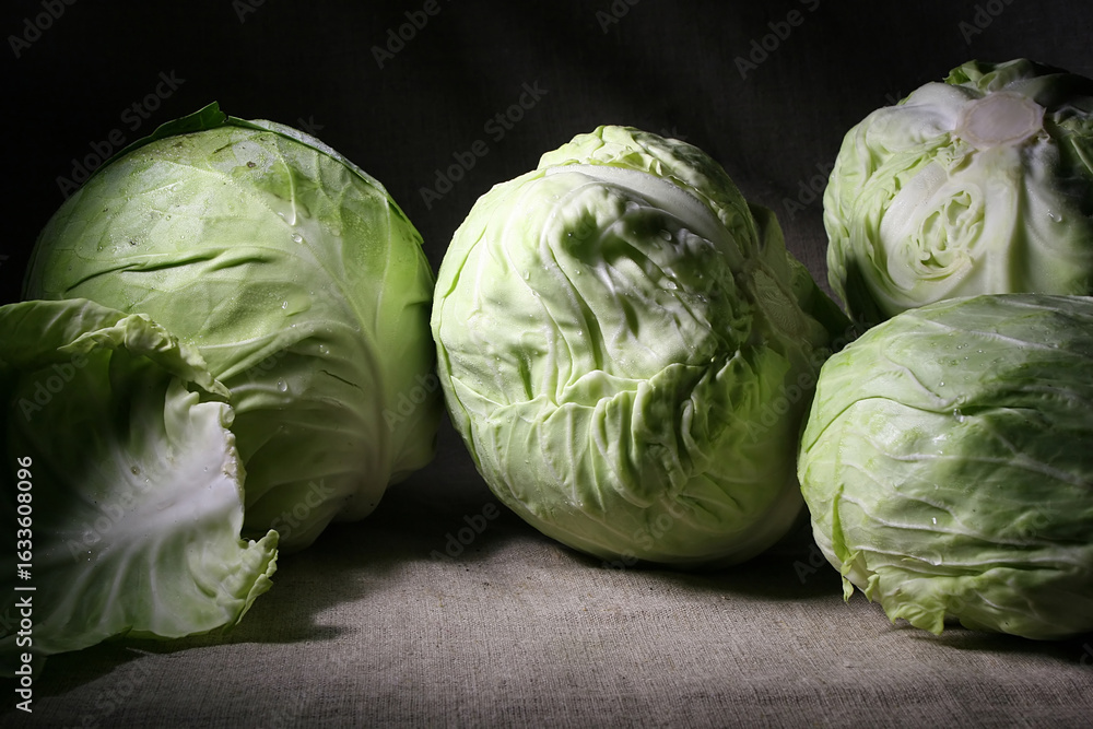 Obraz premium Still life with green young cabbage on dark background