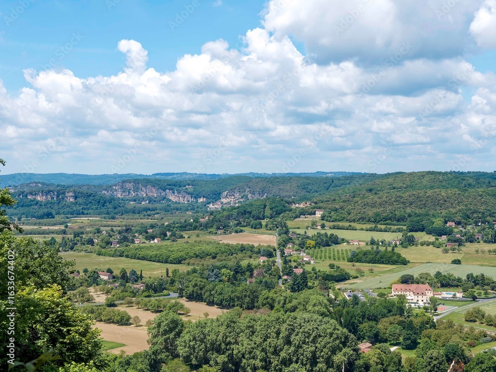 Fototapeta premium Domme, Royal Bastide perched on a hilltop overlooking the Dordogne Valley until La Roque-Gageac at the foot of the towering limestone cliff and Beynac castle into the horizon