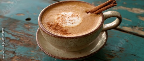 A cup of coffee with a cinnamon stick in it.