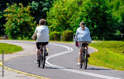 Wallpaper Mural Cyclists ride on the bike path in the city Park
 Torontodigital.ca