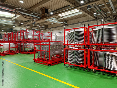 Pallets with manufactured metal parts ready for further processing in an automotive factory