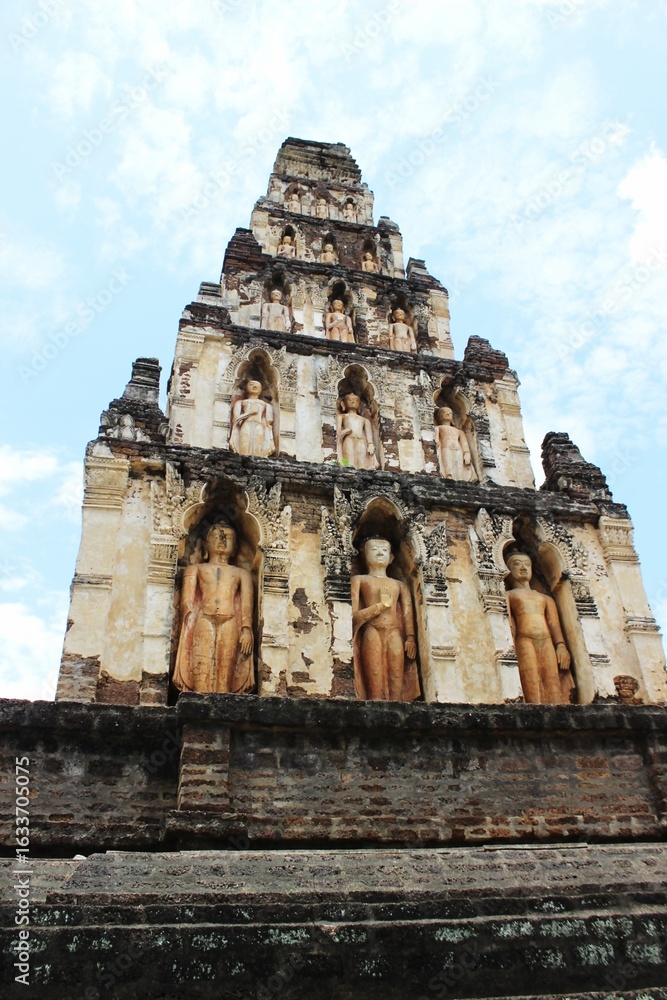 Fototapeta premium Ancient Brick Chedi with Standing Buddha Statues at Wat Chamthewi in Lamphun, Thailand – Hariphunchai Architecture