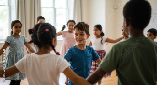 Happy children dancing and holding hands in indoor classroom during group activity, smiling kids wearing casual clothes, joyful learning atmosphere, diverse group celebrating together