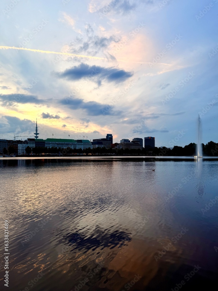 Naklejka premium beautiful lake in the city center, reflections on the water surface, evening cloudy sky