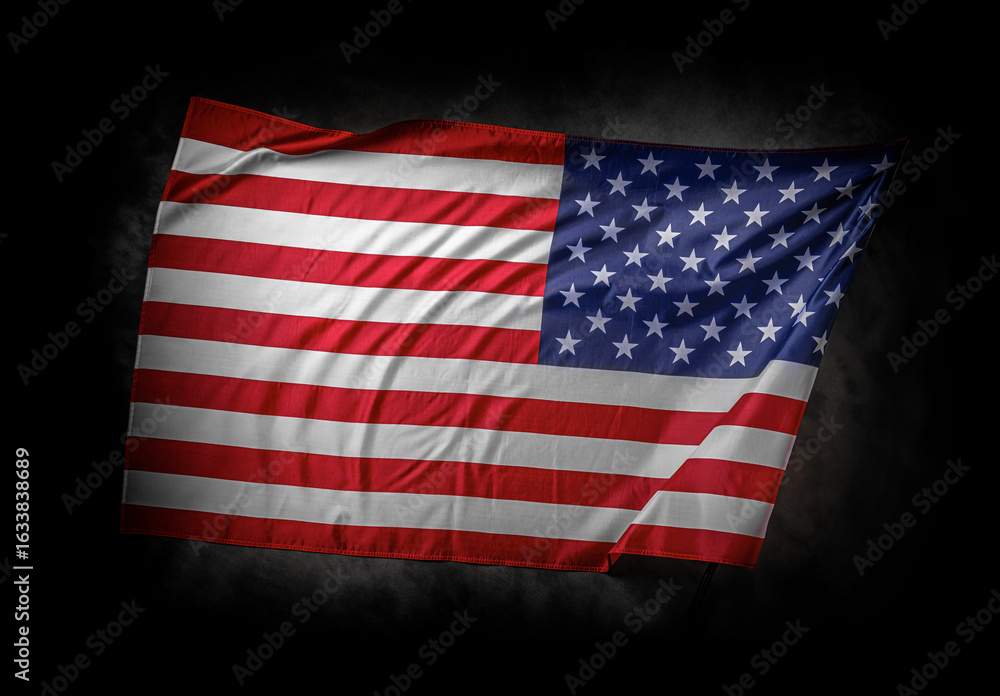 Fototapeta premium A dramatic image of the American flag waving against a dark cloudy background