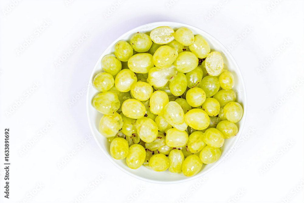 a bowl of grapes on a white surface a bowl of grapes on a white surface