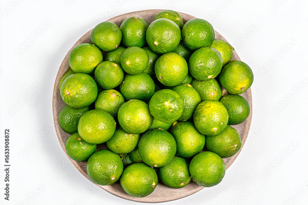 Fototapeta premium a bowl of limes on a white surface