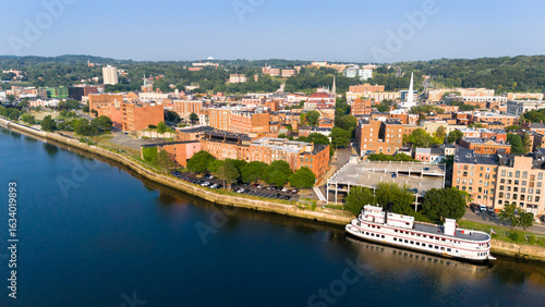 Quadro su tela Aerial view of historic downtown Troy, NY, at sunset with docked riverboat and view towards the east along the Hudson River
