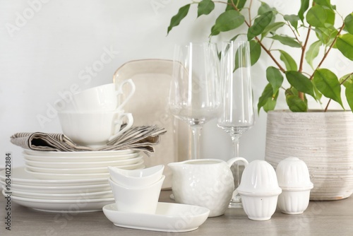 Wallpaper Mural Different clean white dishware, glasses and houseplant on counter in kitchen, closeup Torontodigital.ca