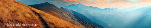 Mountain trail leading along the mountain ridge of beautiful mountains with autumn grass and colorful sky. 