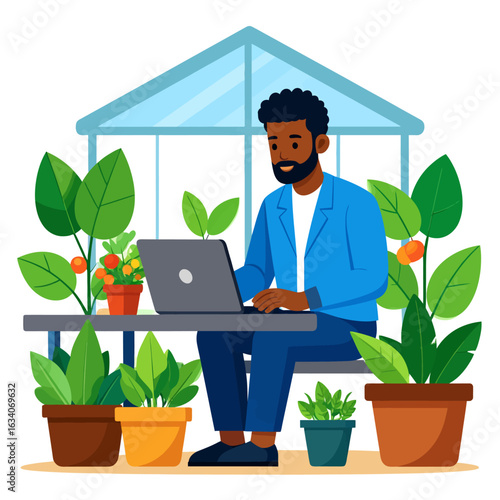 A smiling Black man working on a laptop, surrounded by potted plants in a greenhouse setting.