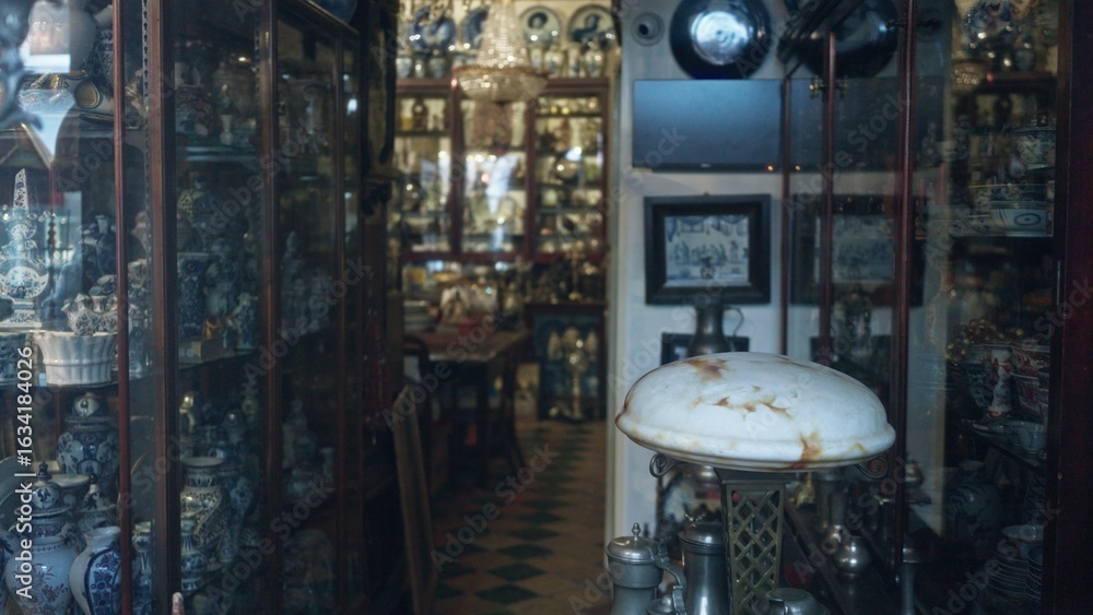 Obraz premium Antique store filled with vintage ceramics and collectibles, showcasing a rich tapestry of history with blurred and defocused elements creating a captivating bokeh effect.