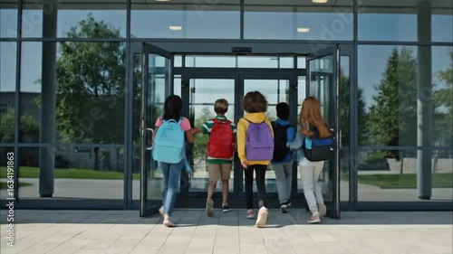 Children with backpacks entering modern school buildingChildren with backpacks entering modern school buildingChildren with backpacks entering modern school buildingChildren with backpacks entering mo