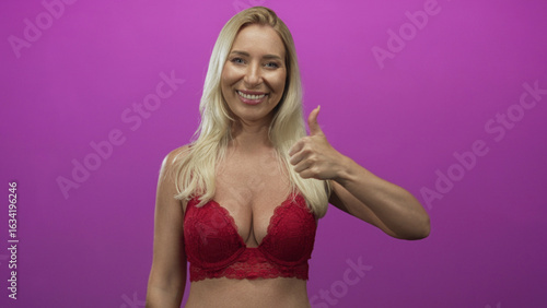 Wallpaper Mural Blonde woman with thumbs up gesture and exposed cleavage wearing red lace bra in studio; optimism confidence. Torontodigital.ca