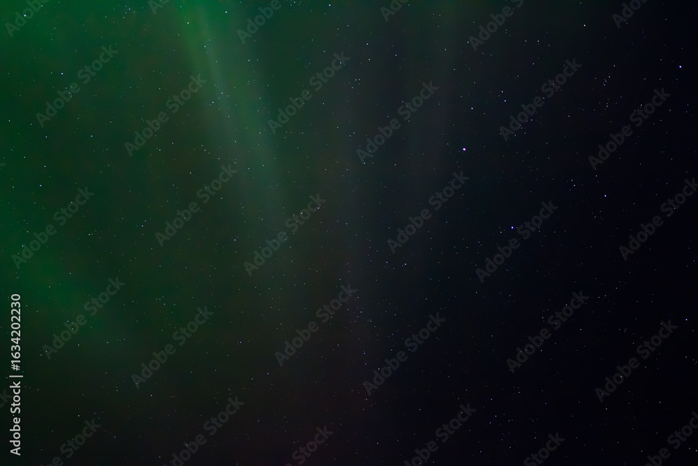 Obraz premium Polar Lights (Aurora borealis). Green northern lights and stars are visible in the dark night sky. Amazing nature of the Arctic. The photo is perfect for the background.