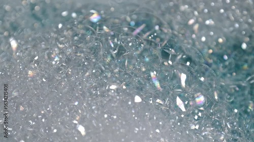 Soap bubbles and droplets on shiny surfaces captured in macro, ideal for illustrating cleanliness, washing rituals, or sterile environments.