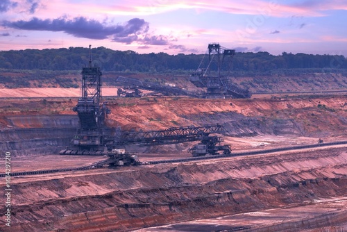Dusk with large excavators in a huge coal mining area