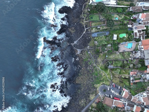 Aerial View of a Wave Crashing Against Volcanic Coastline

