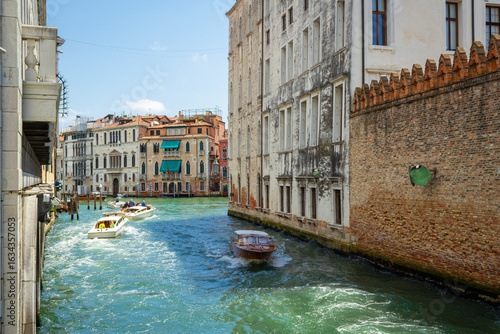 View of the unique and characteristic Venetian canals, where typical boats knew as Gondola are used for tourist sightseeing. Worldwide famous, Venezia is a unique kind of city and UNESCO site.