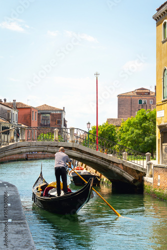 View of the unique and characteristic Venetian canals, where typical boats knew as Gondola are used for tourist sightseeing. Worldwide famous, Venezia is a unique kind of city and UNESCO site.