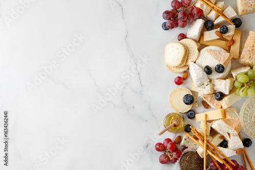 Cheese banner, assortment of traditional cheese, brie, gorgonzola, lambert, livaro, raclette. Antipasto, corner border, copy space. Marble white background, top view.