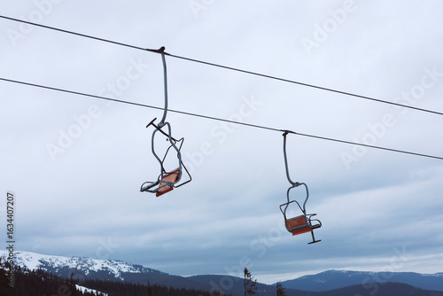 An empty chairlift hung above the snowy landscape