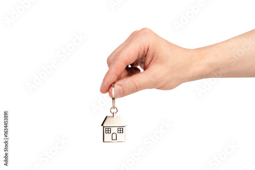 Man's hand holding the keychain with house isolated on white background. Sale, purchase, rent of apartments.
