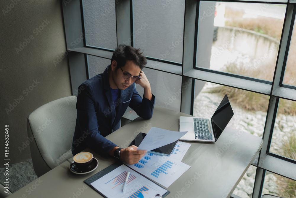 Obraz premium Male office worker overwhelmed by deadlines, staring at screen in frustration.