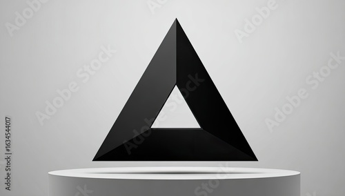 Black, three-dimensional triangle floats on a pedestal
