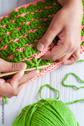 Hands of a Latin woman knitting with crochet