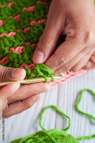 Hands of a Latin woman knitting with crochet