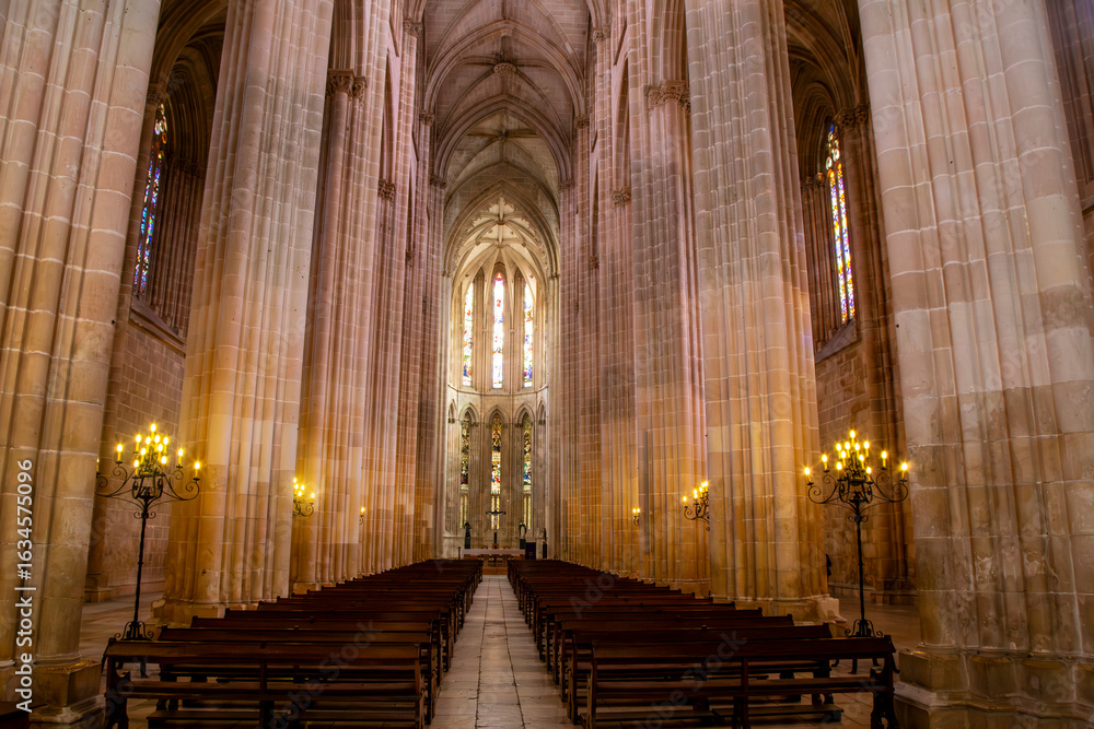 Fototapeta premium The soaring nave and intricate ribbed vault ceiling of the magnificent Batalha Monastery church in Batalha, a masterpiece of Gothic architecture. Portugal