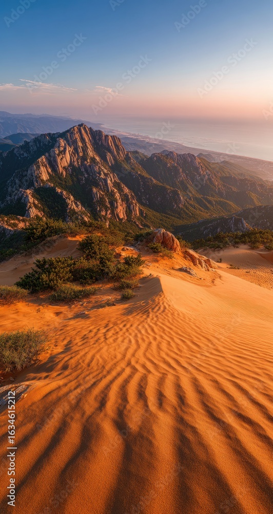 Fototapeta premium Desert mountain panorama at sunrise. Sandy slopes meet rugged peaks under a vibrant sky