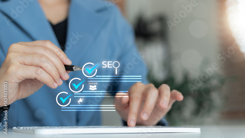 Business using pen and keyboard with virtual SEO checklist icons. Concepts of search engine optimization, content marketing strategy, digital ranking, online visibility, and web traffic growth.