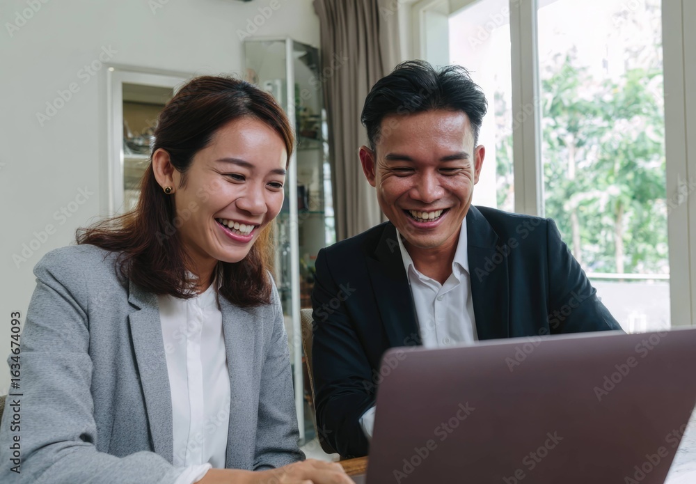 Obraz premium Young Asian Professionals Collaborate in Modern Office with Bright Atmosphere and Engaging Interactions