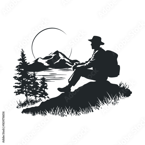 Silhouette of male hiker with backpack in mountain landscape beside lake