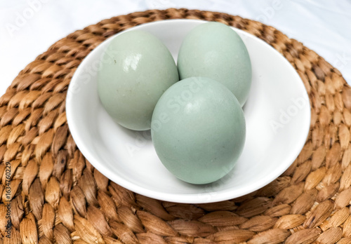 Serving salted duck eggs on white bowl with white background. Salted eggs that have finished the salting process. Selective focus.