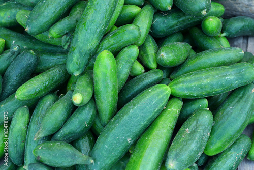 фотографія Close-up of fresh cucumbers with smooth, green skin piled together