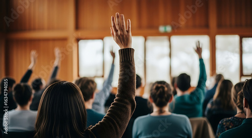 Engaged audience participating in interactive session with raised hands signaling queries or