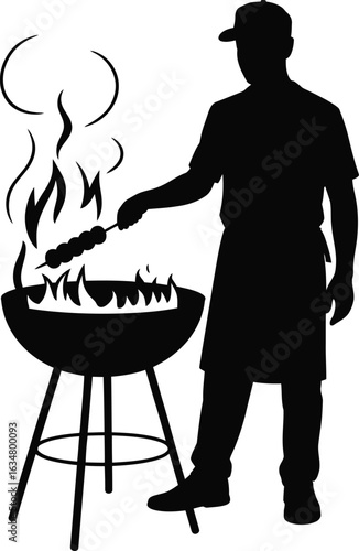 Silhouette of Man Grilling Skewers on Round Barbecue Grill with Flames