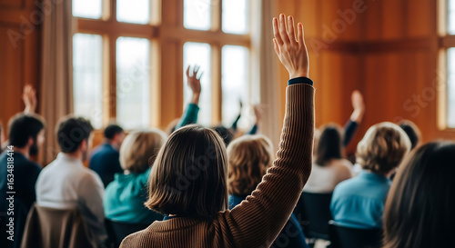 Engaged audience raising hands during a conference or seminar reflecting active participation and