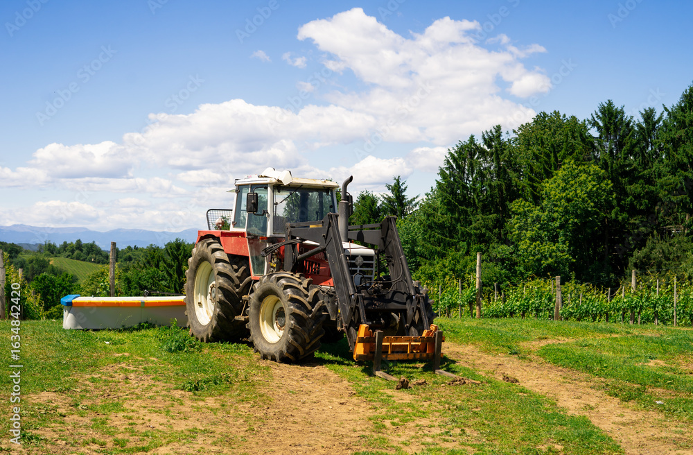 Naklejka premium View of a tractor prepared for work in a farmer's field. Farm equipment. Equipment for working on rural land