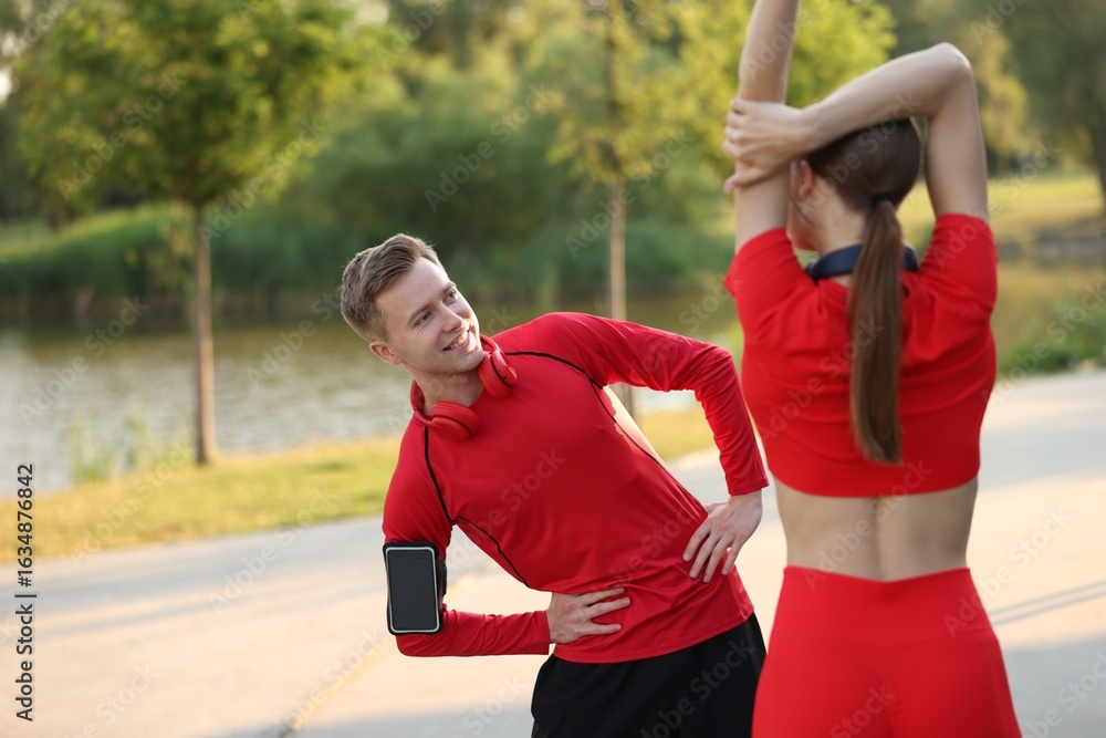 Fototapeta premium Happy couple doing morning exercise outdoors. Healthy lifestyle