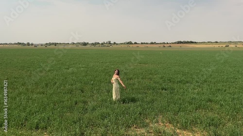 Happy girl standing in green field