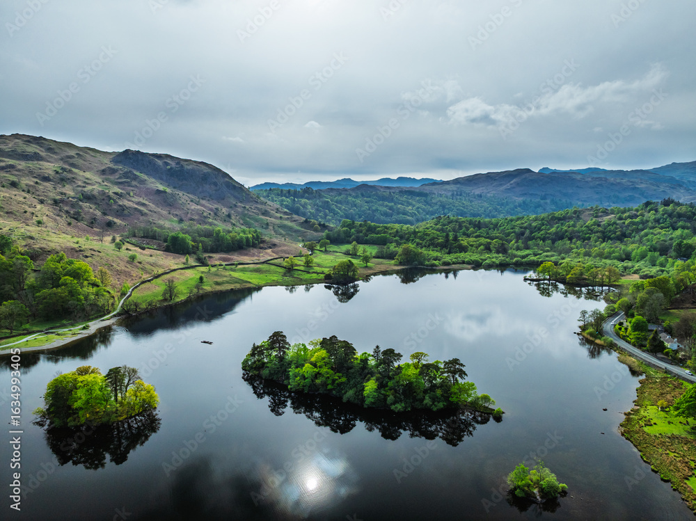 Farms and Mountains over road A591 from a drone, Grasmere Lake, Grasmere, Ambleside, Lake District, Westmorland, Cumbria, UK Farms and Mountains over road A591 from a drone, Grasmere Lake, Grasmere, Ambleside, Lake District, Westmorland, Cumbria, UK