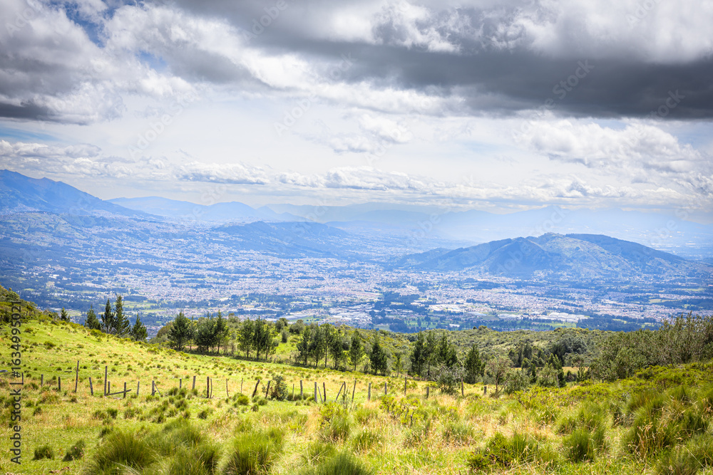 Fototapeta premium Pichincha Province, Quito, Ecuador - July 5, 2025: View of the valleys of southeastern Quito from the Pasochoa Volcano, in the Pasochoa Wildlife Refuge.
